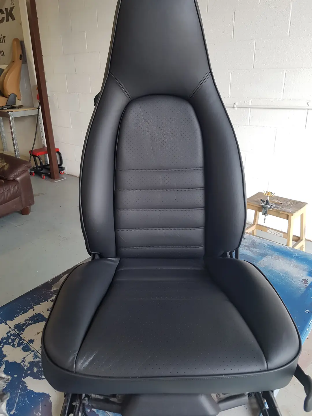 The same black leather sports seat after restoration